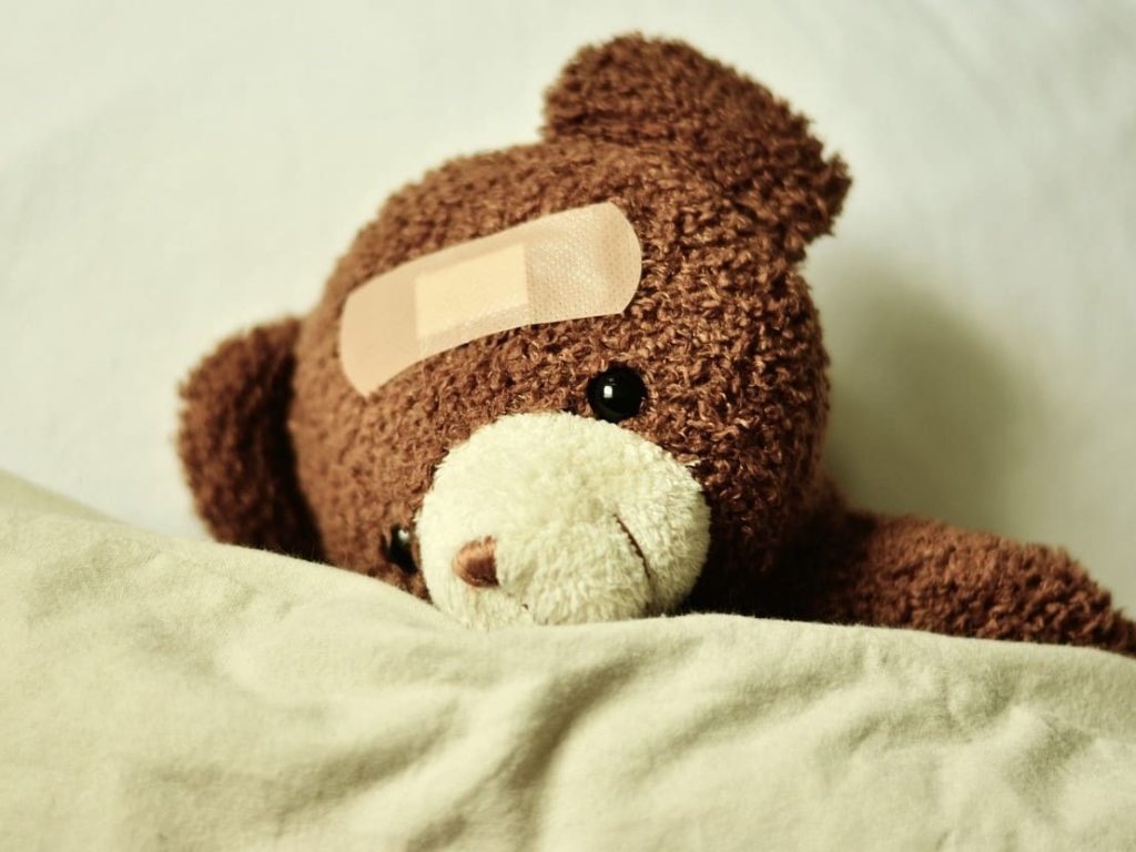 Une peluche ours avec un pansement sur la tête, pour illustrer le soutien de l'immunité et de la fatigue.